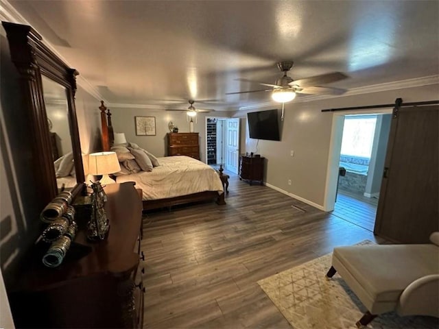 bedroom with ornamental molding, ensuite bath, dark hardwood / wood-style flooring, ceiling fan, and a barn door