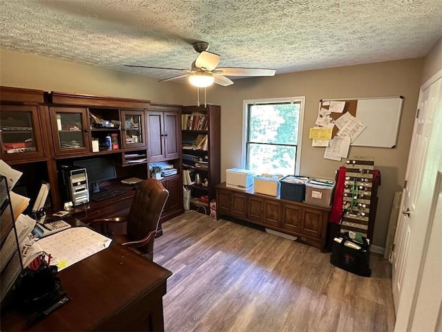 home office featuring a textured ceiling, hardwood / wood-style flooring, and ceiling fan