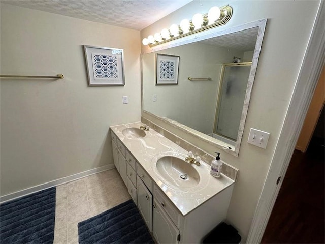 bathroom with vanity, a textured ceiling, an enclosed shower, and tile patterned floors