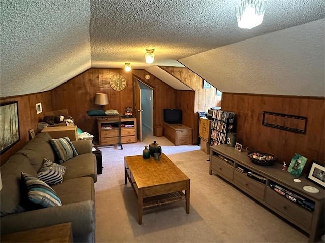 living area with wooden walls, lofted ceiling, a textured ceiling, and light carpet