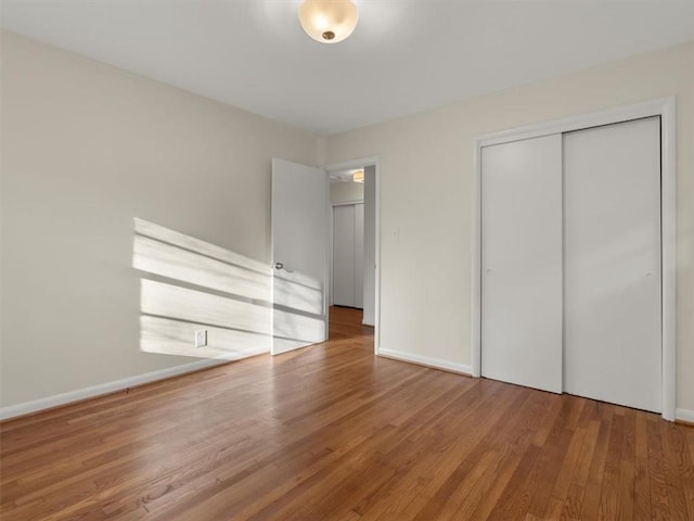 unfurnished bedroom with wood-type flooring and a closet