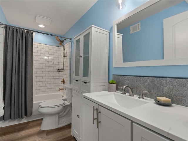 full bathroom with shower / bath combination with curtain, toilet, decorative backsplash, vanity, and hardwood / wood-style flooring