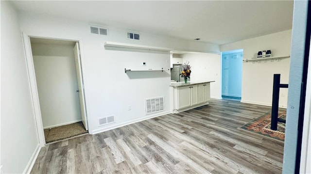spare room featuring wood finished floors and visible vents