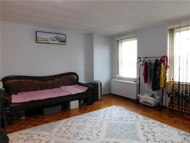 bedroom featuring multiple windows and parquet flooring