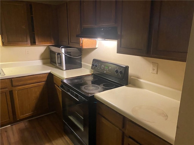 kitchen featuring dark wood-type flooring, black electric range, and ventilation hood