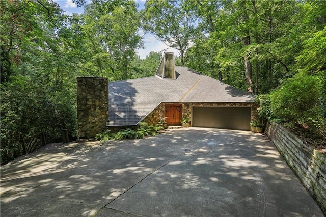 562 Pine Valley Rd SE, Marietta, GA 30067 - view of front facade featuring a chimney, stone siding, concrete driveway, and a garage