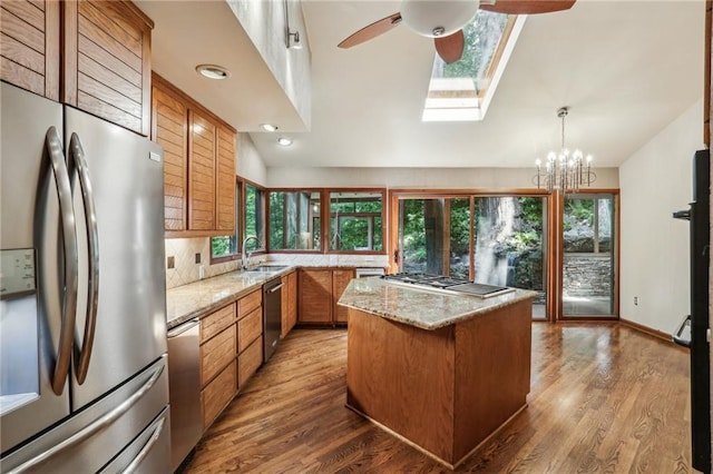 562 Pine Valley Rd SE, Marietta, GA 30067 - kitchen featuring appliances with stainless steel finishes, brown cabinets, ceiling fan, a skylight, and lofted ceiling