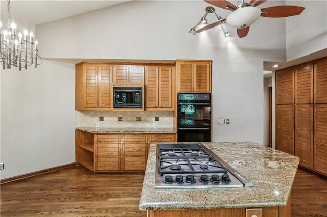 562 Pine Valley Rd SE, Marietta, GA 30067 - kitchen featuring black appliances, decorative backsplash, brown cabinets, dark wood-style flooring, and a center island