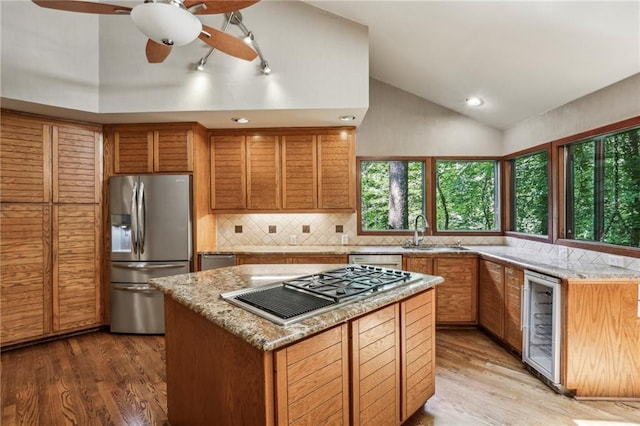 562 Pine Valley Rd SE, Marietta, GA 30067 - kitchen featuring stainless steel appliances, wine cooler, light wood-style floors, decorative backsplash, and light stone counters