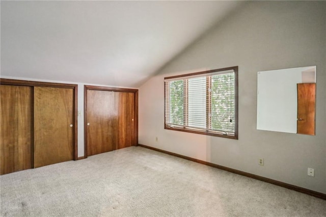 562 Pine Valley Rd SE, Marietta, GA 30067 - unfurnished bedroom featuring lofted ceiling, carpet flooring, and two closets