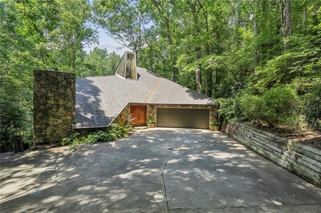 562 Pine Valley Rd SE, Marietta, GA 30067 - view of front facade with stone siding, a chimney, concrete driveway, and an attached garage