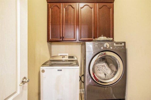 washroom featuring washer and clothes dryer and cabinets