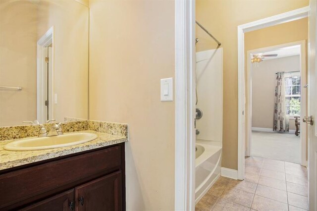 bathroom featuring tile patterned flooring, vanity, and  shower combination