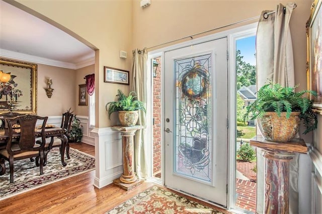 foyer entrance with hardwood / wood-style flooring and crown molding