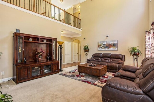 carpeted living room with a towering ceiling