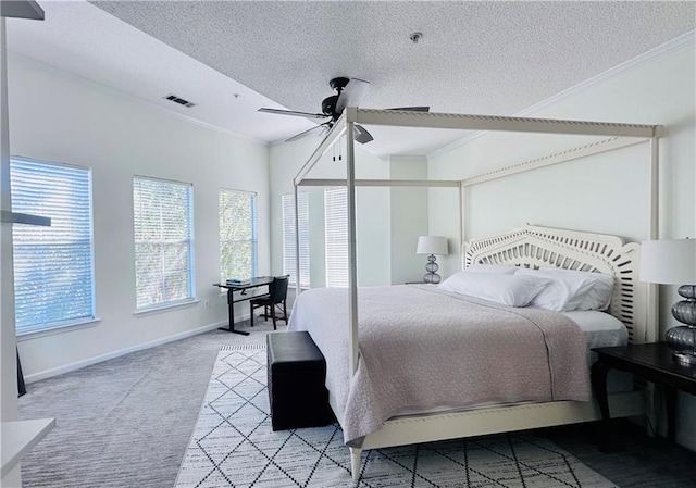 bedroom featuring ceiling fan, crown molding, a textured ceiling, and light carpet