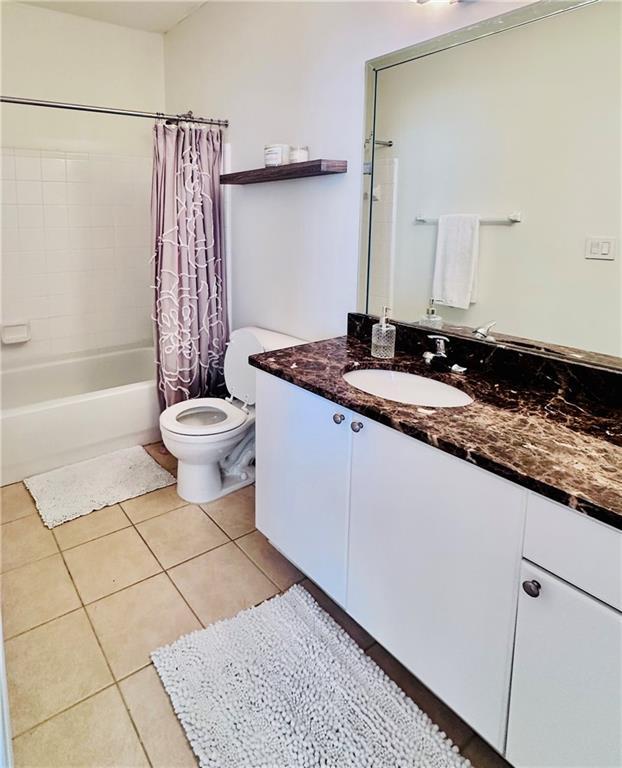 full bathroom with tile patterned floors, vanity, toilet, and shower / tub combo with curtain