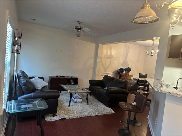 living area featuring dark wood-style floors, visible vents, and a ceiling fan