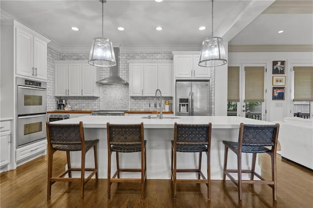3075 Woodvale Ct, Alpharetta, GA 30022 - kitchen with appliances with stainless steel finishes, a sink, wall chimney range hood, white cabinets, and ornamental molding