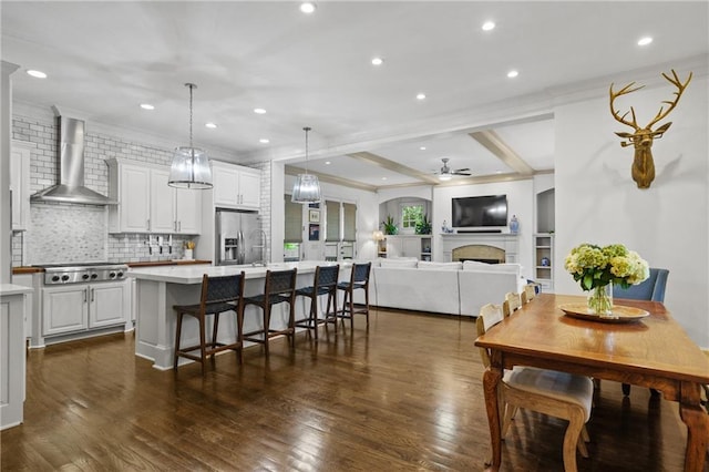 3075 Woodvale Ct, Alpharetta, GA 30022 - kitchen featuring wall chimney exhaust hood, appliances with stainless steel finishes, ceiling fan, a kitchen island, and light countertops