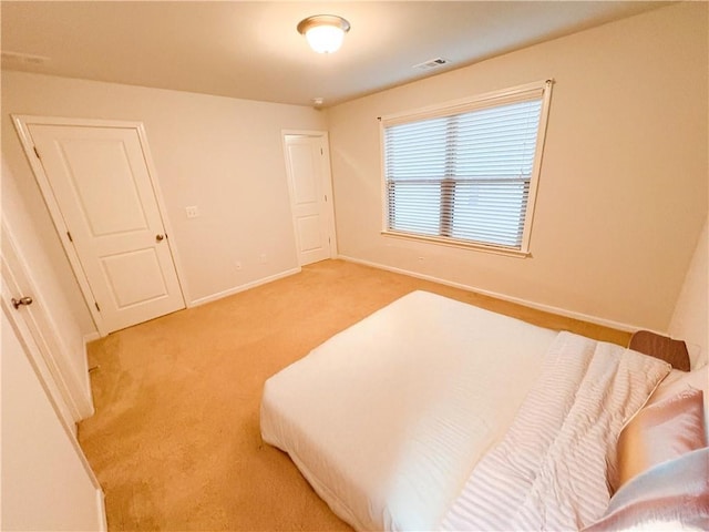 bedroom featuring light colored carpet, visible vents, and baseboards