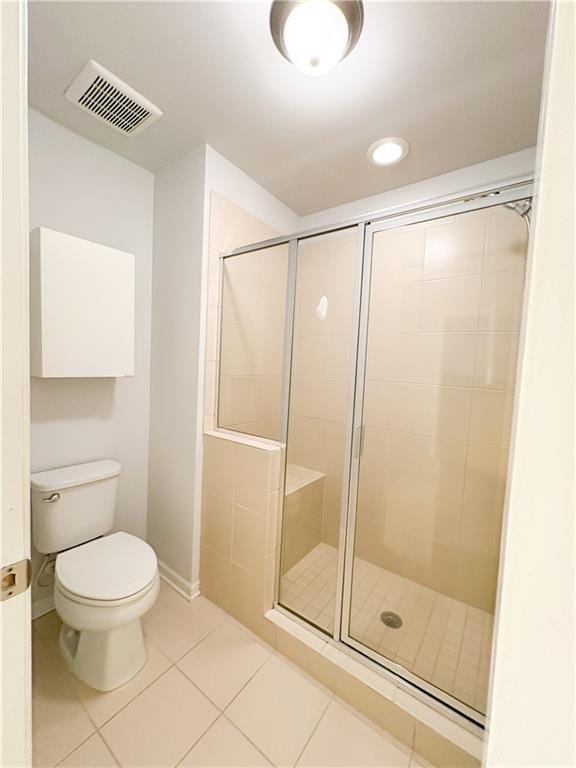 bathroom with toilet, an enclosed shower, and tile patterned floors