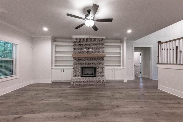 unfurnished living room with ceiling fan, built in features, a fireplace, and crown molding