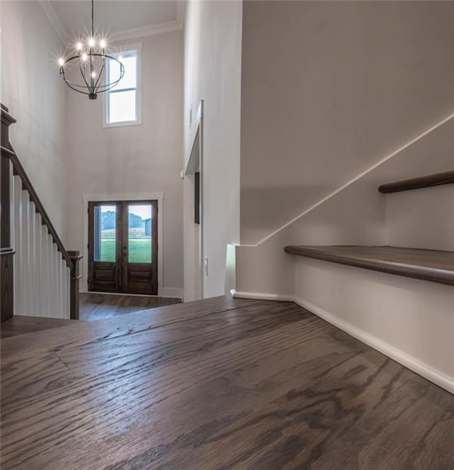 entryway featuring french doors, an inviting chandelier, and crown molding