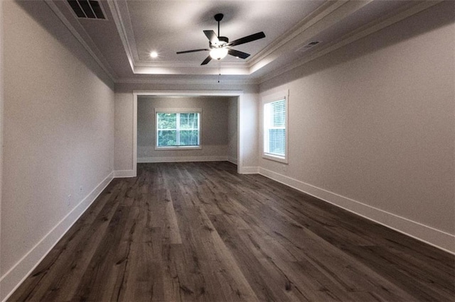 spare room with ceiling fan, a tray ceiling, dark hardwood / wood-style flooring, and crown molding