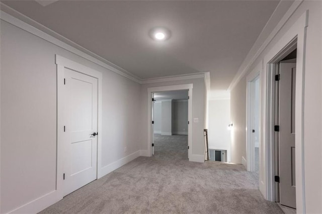 corridor with light carpet and crown molding