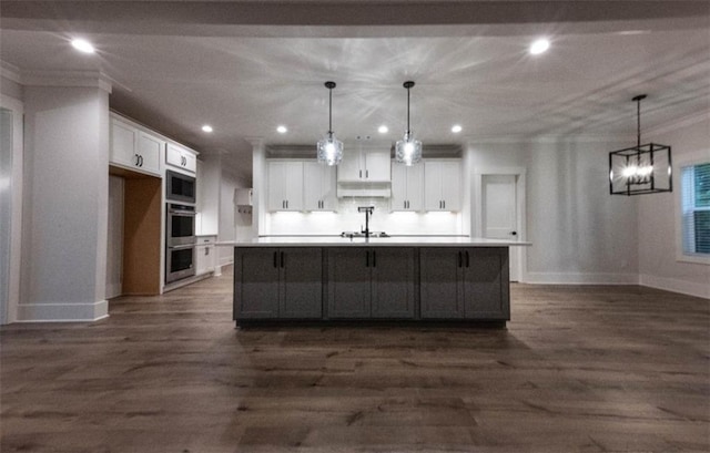 kitchen featuring decorative light fixtures, white cabinetry, and a large island