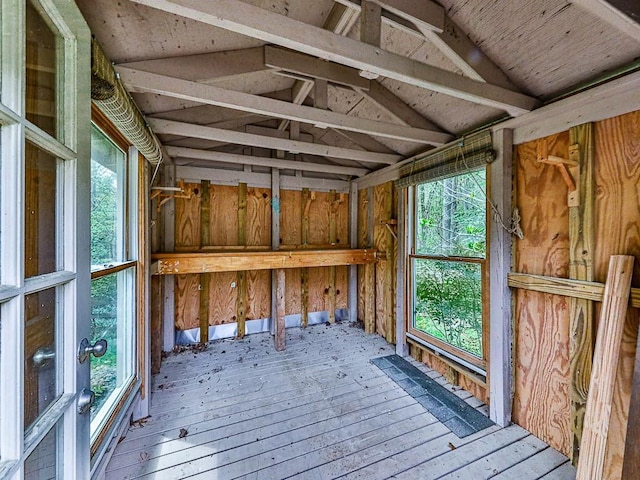 miscellaneous room with lofted ceiling, wood-type flooring, and wood walls