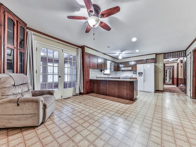 kitchen with french doors, crown molding, kitchen peninsula, white fridge with ice dispenser, and ceiling fan