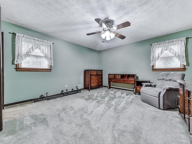 unfurnished room featuring a textured ceiling, ceiling fan, and carpet flooring