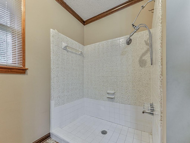 bathroom featuring crown molding, tiled shower, and a textured ceiling