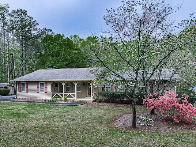 ranch-style house featuring a front yard and covered porch