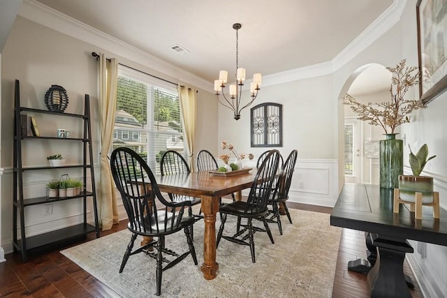 4003 Coachman Ct, Cumming, GA 30040 - dining room featuring arched walkways, crown molding, dark wood-style floors, a chandelier, and wainscoting