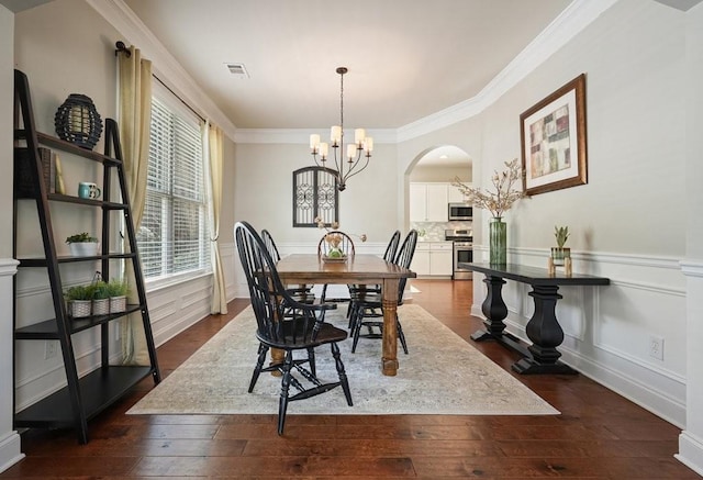 4003 Coachman Ct, Cumming, GA 30040 - dining space featuring arched walkways, a chandelier, ornamental molding, wainscoting, and dark wood-style floors