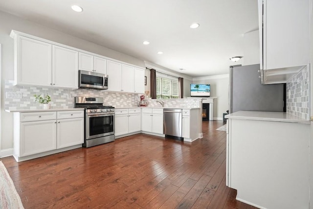 4003 Coachman Ct, Cumming, GA 30040 - kitchen featuring stainless steel appliances, a peninsula, decorative backsplash, white cabinets, and light countertops