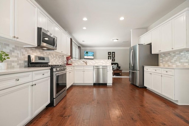 4003 Coachman Ct, Cumming, GA 30040 - kitchen featuring appliances with stainless steel finishes, a peninsula, white cabinetry, light countertops, and recessed lighting