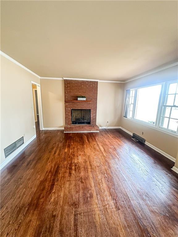 unfurnished living room featuring dark wood-type flooring, a fireplace, and ornamental molding