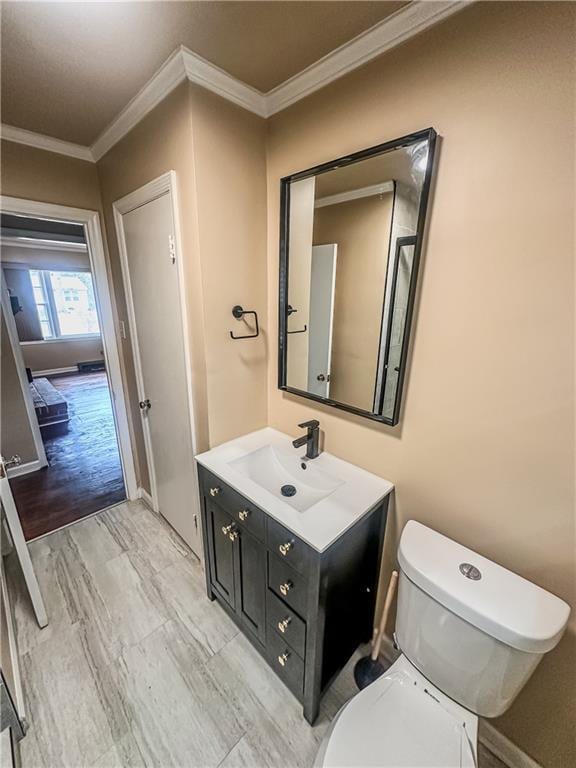 bathroom with vanity, crown molding, and toilet