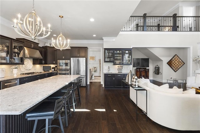 1250 Atherton Park, Roswell, GA 30076 - kitchen featuring stainless steel appliances, a chandelier, crown molding, under cabinet range hood, and a breakfast bar area