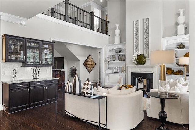 1250 Atherton Park, Roswell, GA 30076 - living area featuring a towering ceiling, dark wood-style floors, bar with sink, ornamental molding, and built in features