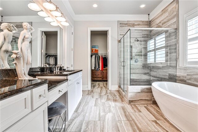 1250 Atherton Park, Roswell, GA 30076 - bathroom with vanity, a walk in closet, a freestanding tub, a stall shower, and crown molding