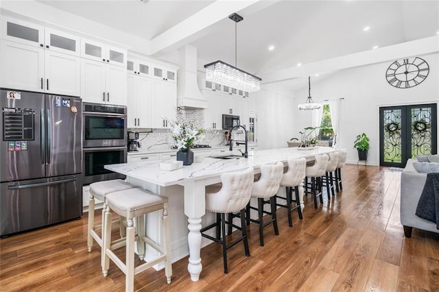 kitchen with decorative backsplash, a spacious island, vaulted ceiling with beams, stainless steel appliances, and recessed lighting