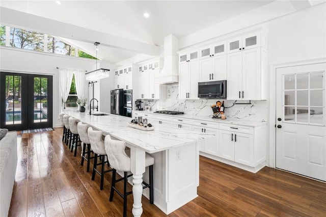 kitchen with black cooktop, a sink, premium range hood, freestanding refrigerator, and dark wood-type flooring