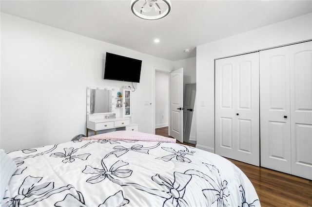 bedroom with recessed lighting, a closet, and dark wood-style floors