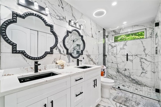 bathroom featuring double vanity, marble finish floor, toilet, tile walls, and a marble finish shower