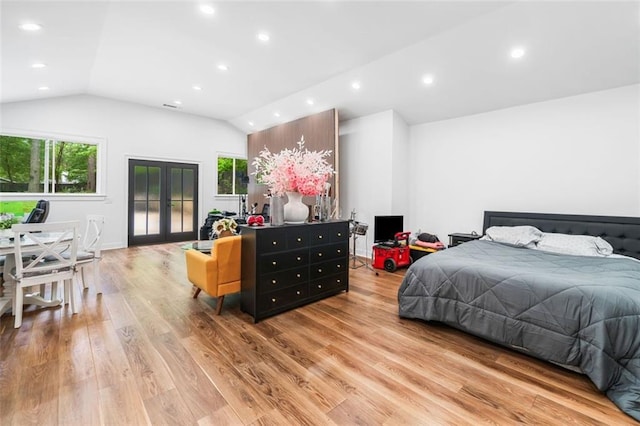 bedroom with vaulted ceiling, multiple windows, french doors, and light wood-style floors
